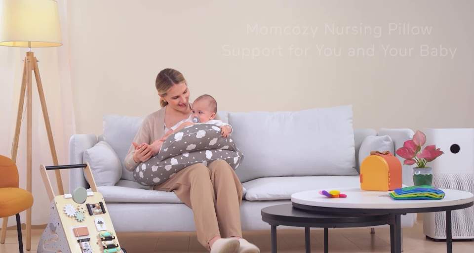 Cozy mom cradling newborn on ergonomic memory foam nursing pillow during soft-lit night feed.