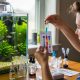 Beginner testing aquarium water with a liquid test kit next to a freshwater fish tank