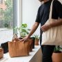 Shopper examining plant-based leather coat in modern New York designer showroom.